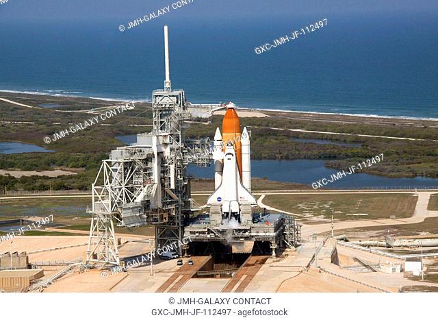 On Launch Pad 39A at NASA's Kennedy Space Center in Florida, space shuttle Discovery awaits the liftoff of its final scheduled mission