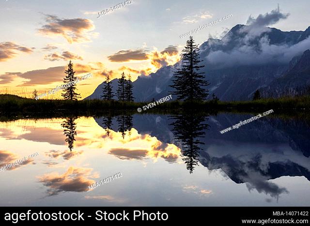 reflection of the hochkönig massif in a small pond