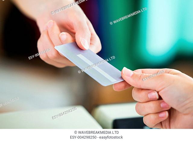 Close-up of a young woman paying with her credit card