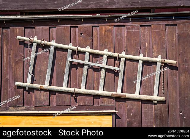 Wooden ladder hanging on the wall of a shed in the country