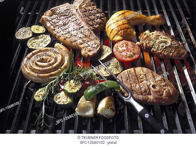 Meat, poultry and vegetables on a grill grate