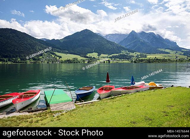 Boats on the shore of Walchsee, in the background the Kaisergebirge with Ebersberg (1164 m), Heuberg (1603 m) and the mountain range of the Zahmen Kaiser