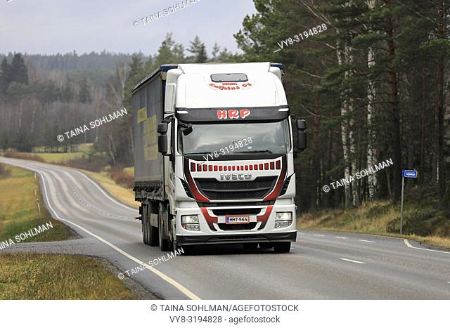 Salo, Finland - November 16, 2018: Iveco Stralis truck of HMK Kuljetus Oy pulls trailer along rural highway on overcast day of autumn in Finland
