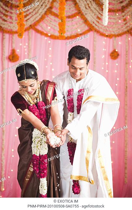 Bride and bridegroom performing a religious ceremony during south Indian wedding