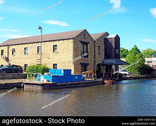 a view of buildings around the brighouse basin with moored boat on the calder and hebble navigation canal in calderdale west yorkshire