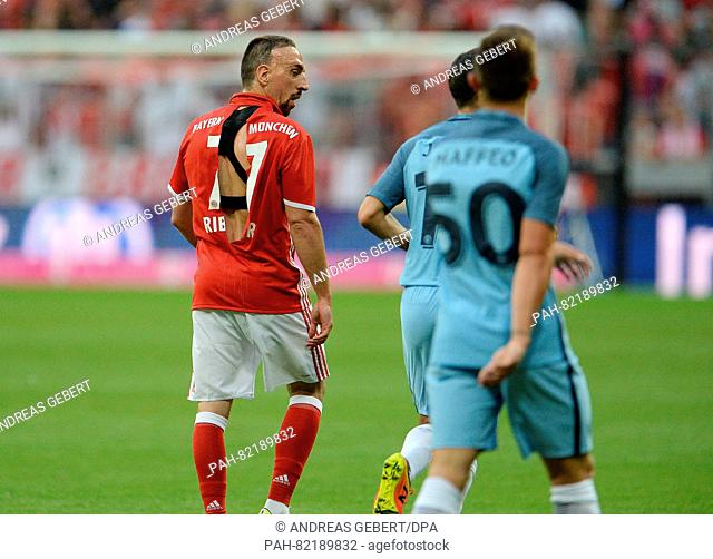 Munich's Franck Ribery (L) wearing a ripped jersey walks across the pitch next to Manchester's Pablo Maffeo during an international soccer friendly match...