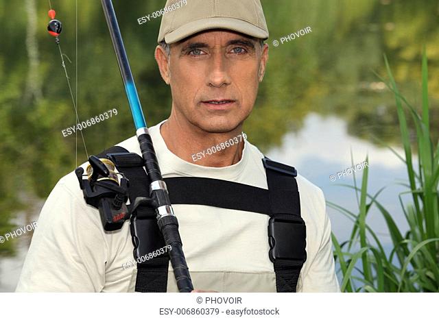 handsome middle-aged fisherman by riverside