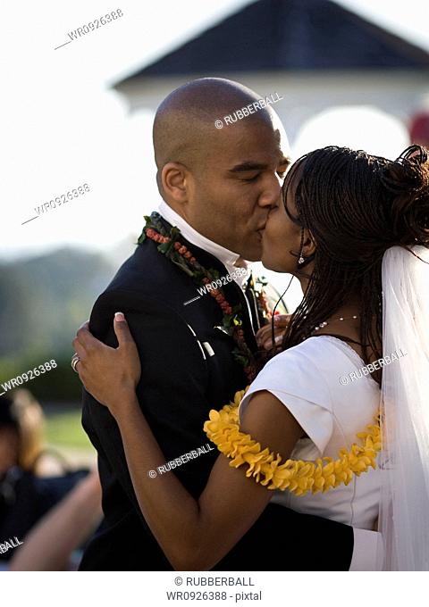 Close-up of a bride and groom kissing