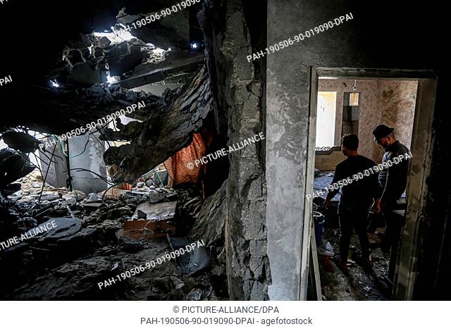 06 May 2019, Palestinian Territories, Beit Lahia: Palestinians inspect the damage at a building destroyed during Israeli airstrikes on Beit Lahia
