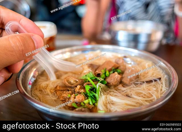 eating Taiwan snack of thin noodles with pork intestine