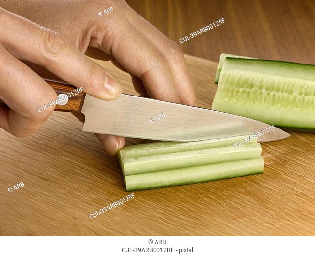 Close up of woman chopping cucumber