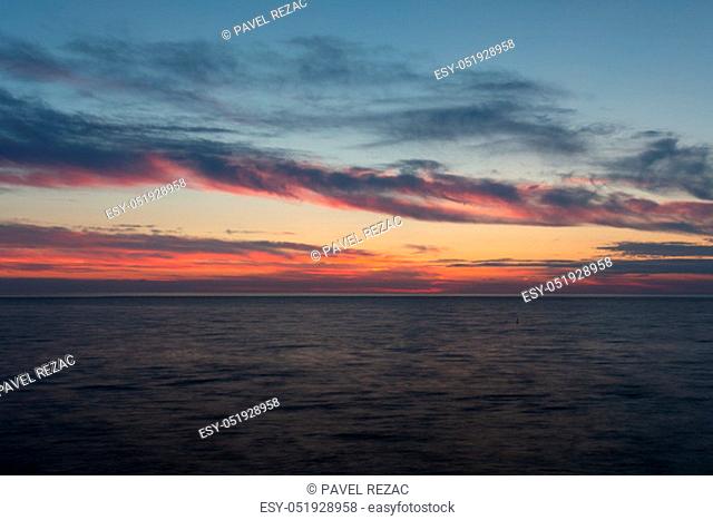 Beautiful sky with clouds at sunset over Adriatic sea near Peschici town on Gargano peninsula, Italy