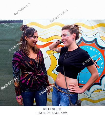 Women talking near multicolor mural