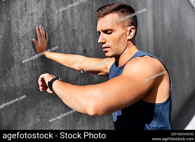 young man with fitness tracker on city street