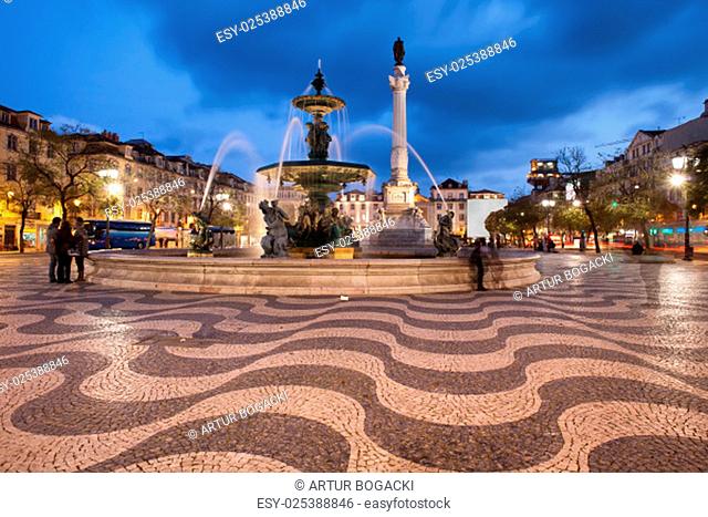 Fountain and Column of Dom Pedro IV on Rossio Square at night in Lisbon, Portugal