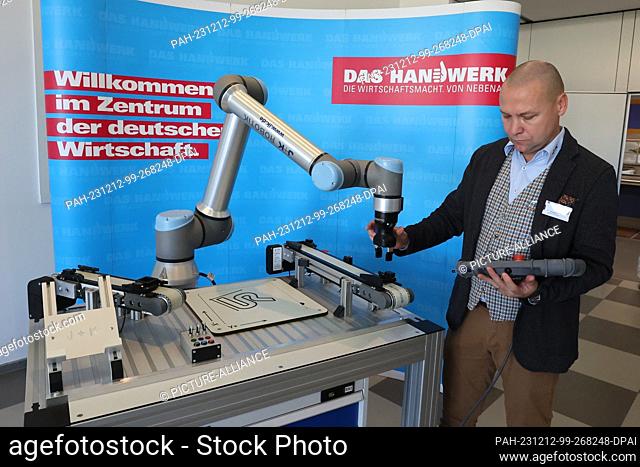12 December 2023, Thuringia, Erfurt: Christian Held from Jugard+Künstner works at a robotics learning station at the launch event for the Competence Center for...