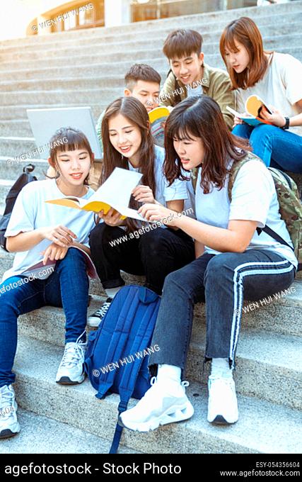 Group of students studying on the stairs at campus