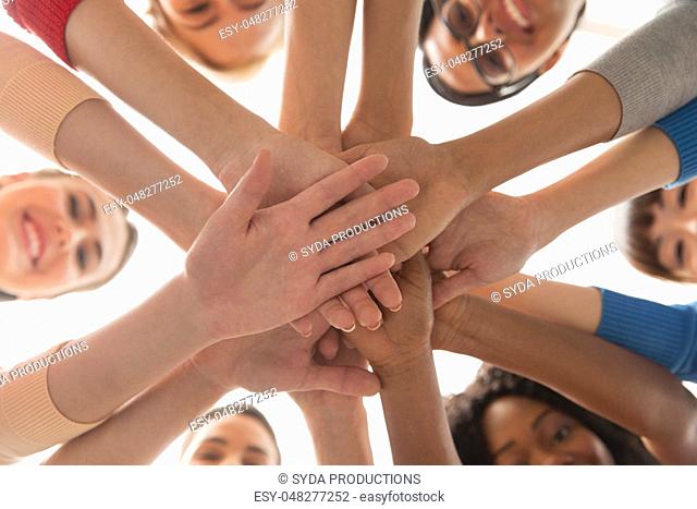 close up of international women stacking hands