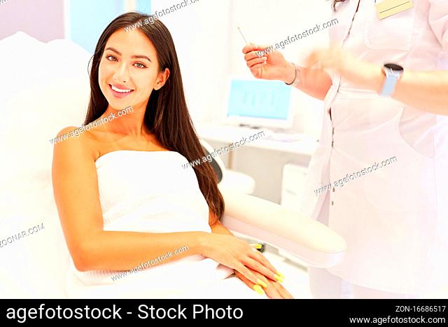 Lächelnde junge Frau als Patientin im Kosmetikstudio oder in der Schönheitsklinik