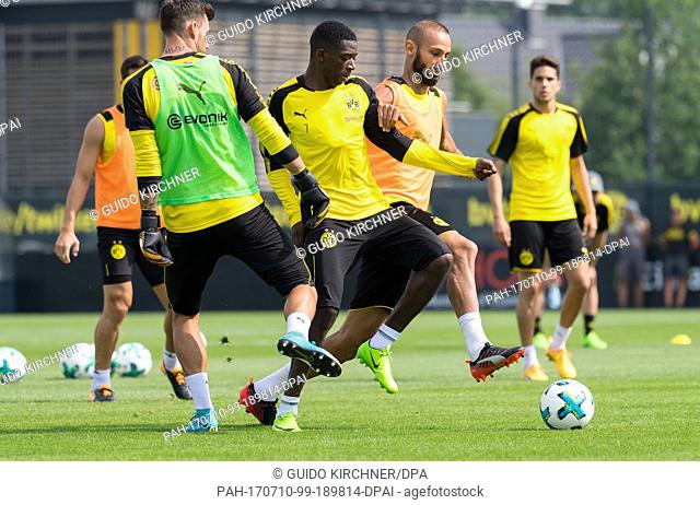 Dortmund goalie Roman Buerki, Dortmund's Ousmane Dembele and Dortmund's new signing Omer Toprak (l-r) vie for the ball during a public training session by...