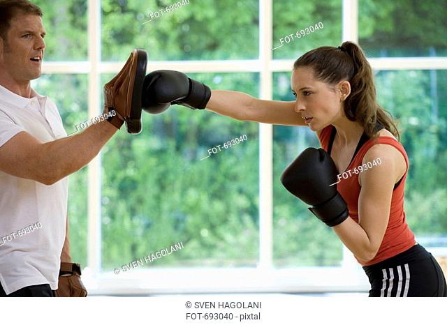 A female boxer working with a trainer