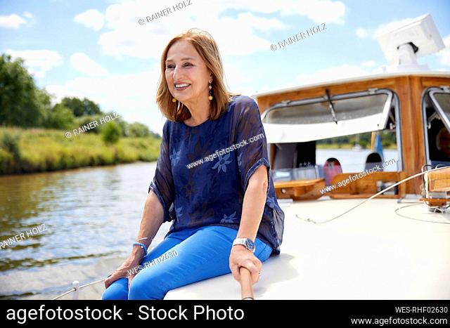 Senior woman sitting on boat deck at vacation