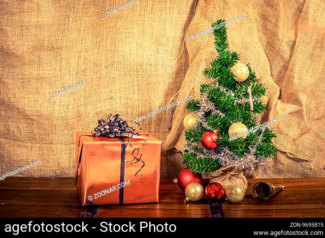 Christmas gift on a wooden table with shiny baubles