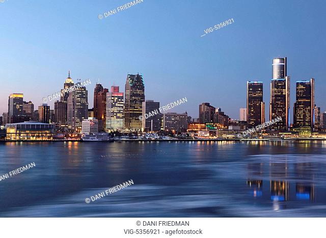 Skyline of downtown Detroit, Michigan, USA. Ice can be seen floating on the Detroit River as the buildings are illuminated at dusk