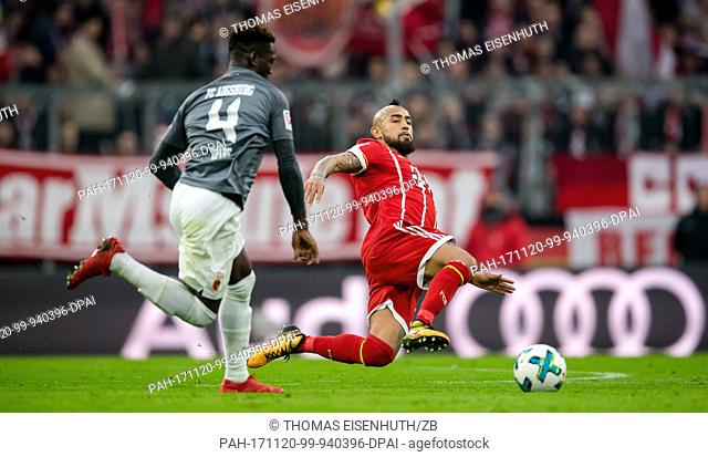 Munich's Arturo Vidal and Augsburg's Daniel Opare vie for the ball during the Bundesliga soccer match between Bayern Munich and FC Augsburg at the Allianz Arena...