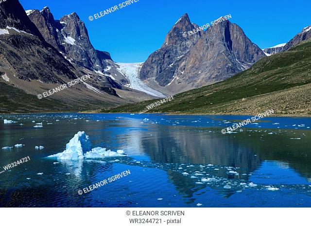 Blue iceberg, pyramidal peaks, glacier, rugged South Skjoldungen Fjord and Island, glorious weather, remote East Greenland, Denmark, Polar Regions