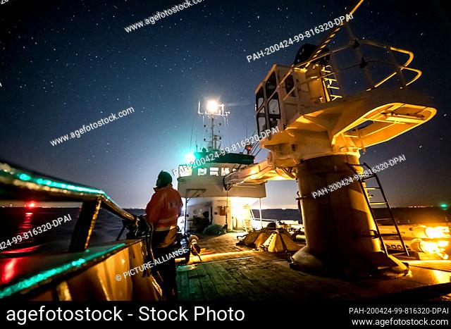 23 April 2020, Schleswig-Holstein, Helgoland: A scientist stands at the railing of the buoy-laying vessel ""Lev Taifun"" shortly after the departure to...