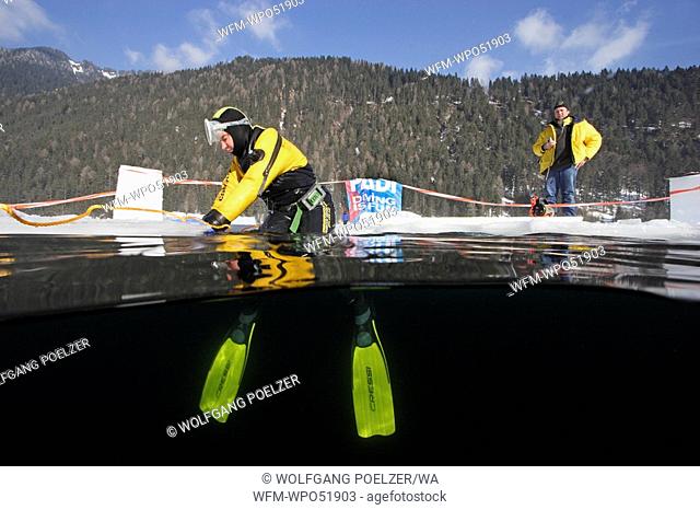 Ice-Diver sitting on the Ice Hole, Lake Weissensee, Carinthia, Austria