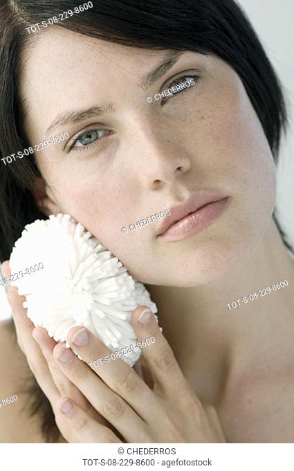 Portrait of a mid adult woman scrubbing her face with a scrubber