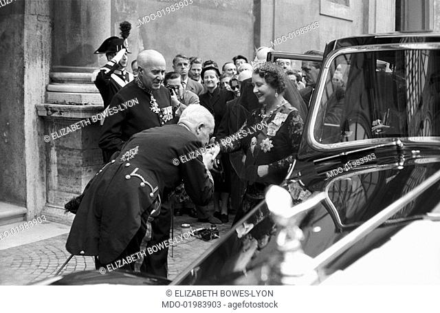 The Queen Mother Elizabeth Bowes-Lyon, just got out of a luxurious car, receives the gracious tribute of two old soldiers in uniform