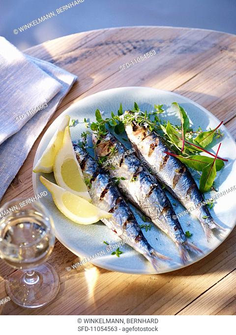 Grilled sardines with lemon wedges