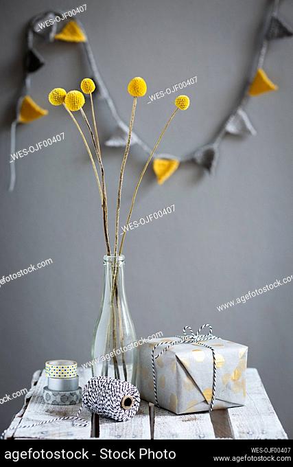 Wrapped gift and bottle¶ÿwith blooming billy buttons