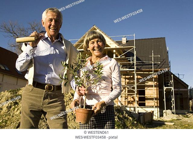 Senior couple in front of partially built house