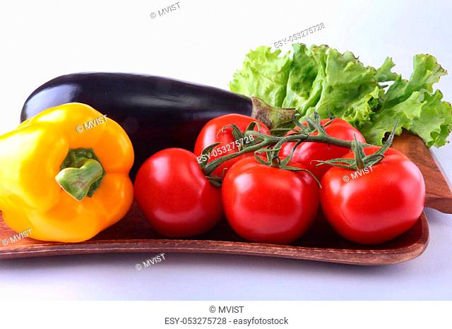 Fresh assorted vegetables, eggplant, bell pepper, tomato, garlic with leaf lettuce. Isolated on white background. Selective focus