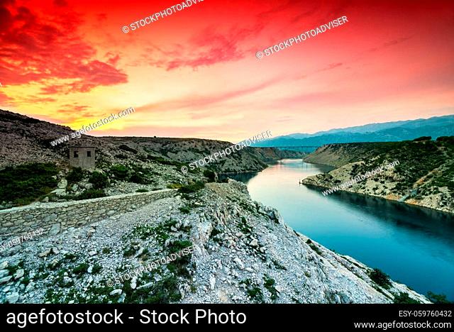 Colorful evening scenic view from Maslenica bridge over the river and mountains with dramatic sunset sky in Dalmatia, Croatia