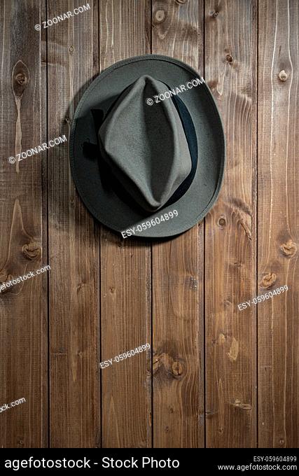 an old hat hanging on a wooden wall