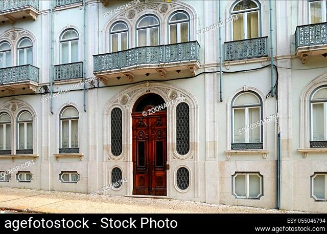 Fragment of the facade of a historic building in Lisbon, front door, windows and a balcony