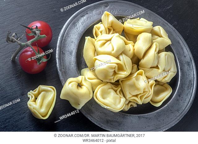Mampf: Frische Tortellini auf einem Zinnteller. Fresh tortellini on an antique pewter plate