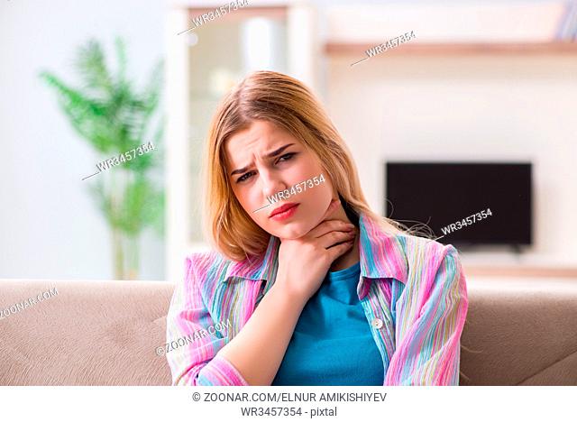 Young woman suffering from sore throat pain