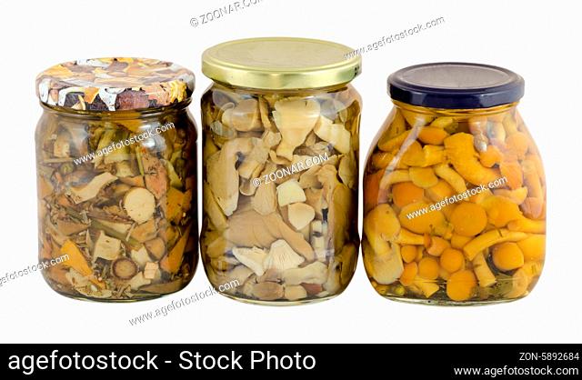 three glass jar of pickled variety forest mushrooms isolated on white background
