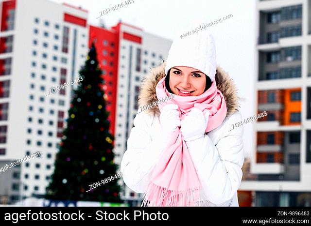 Beautiful young woman near christmas tree outdoors in winter season