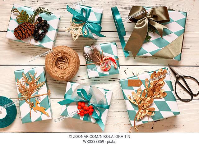 Creatively wrapped and decorated christmas presents in boxes on white wooden background.Top view from above