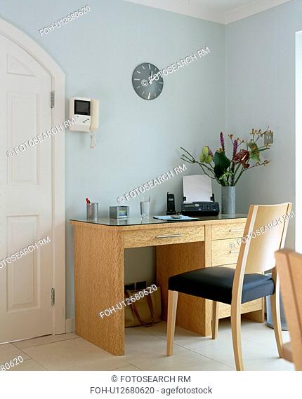 Answerphone on pale wood desk with matching chair in pastel blue home office