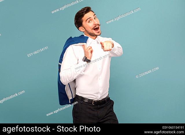 wondered and pointing finger at camera portrait of handsome bearded businessman in white shirt holding his blue jacket, with smart watch
