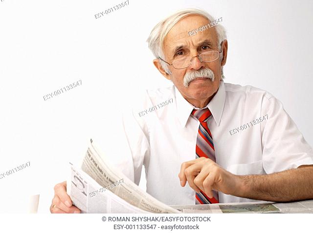 Portrait of an elder man holding an newspaper and looking at you