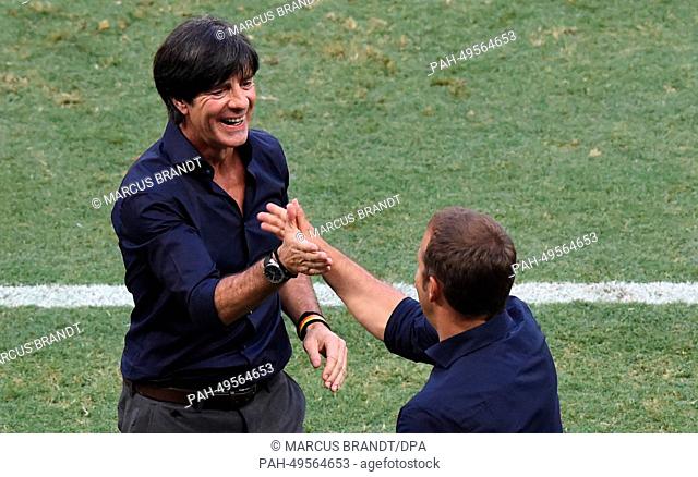 Germany's head coach Joachim Loew (L) and assistant coach Hans-Dieter Flick celebrate during the FIFA World Cup 2014 group G preliminary round match between...